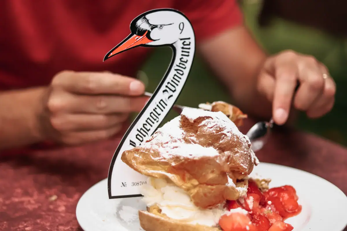 Windbeutel Eine Person isst ein Dessert auf einem Teller.