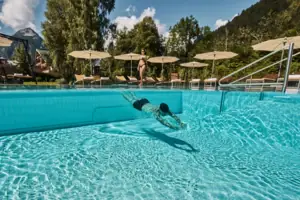 Außenpool Ein Mann schwimmt in einem Pool.