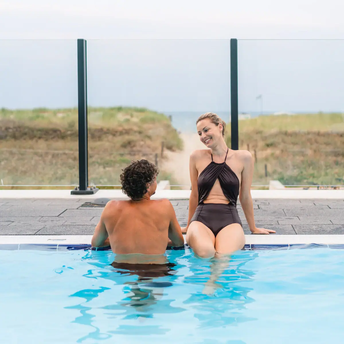 Außenpool Warnemünde Ein Mann und eine Frau sitzen in einem Pool.