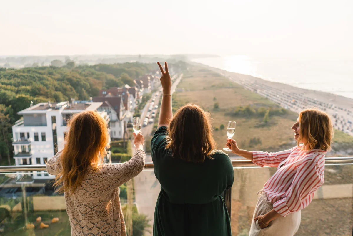 Ausblick vom Balkon Eine Gruppe von Menschen hält Weingläser und steht auf einem Balkon.