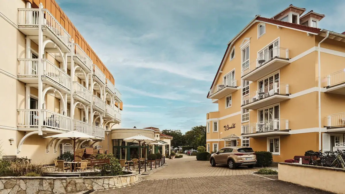Hotelauffahrt Straße mit Gebäuden und geparkten Autos.