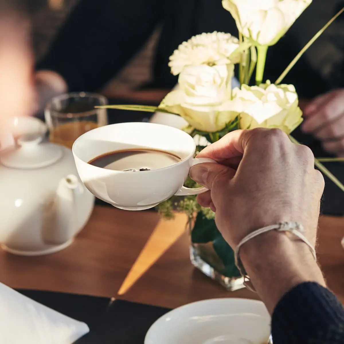 Eine Person hält eine Tasse Kaffee.