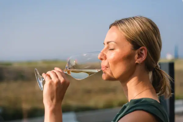 Getränke im aja Warnemünde Eine Frau trinkt aus einem Weinglas.