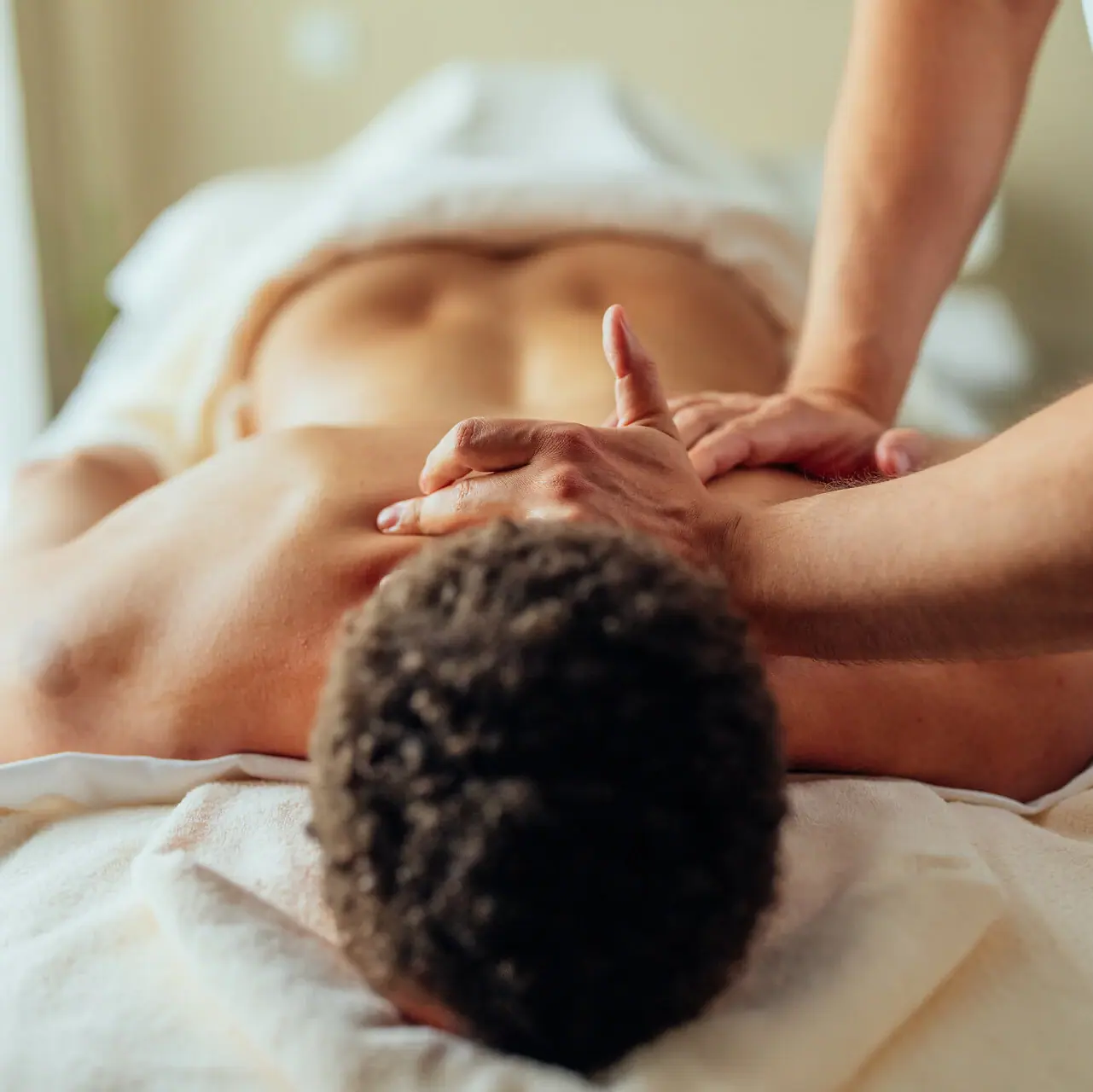 Massage Ein Mann liegt auf einem Massagetisch.