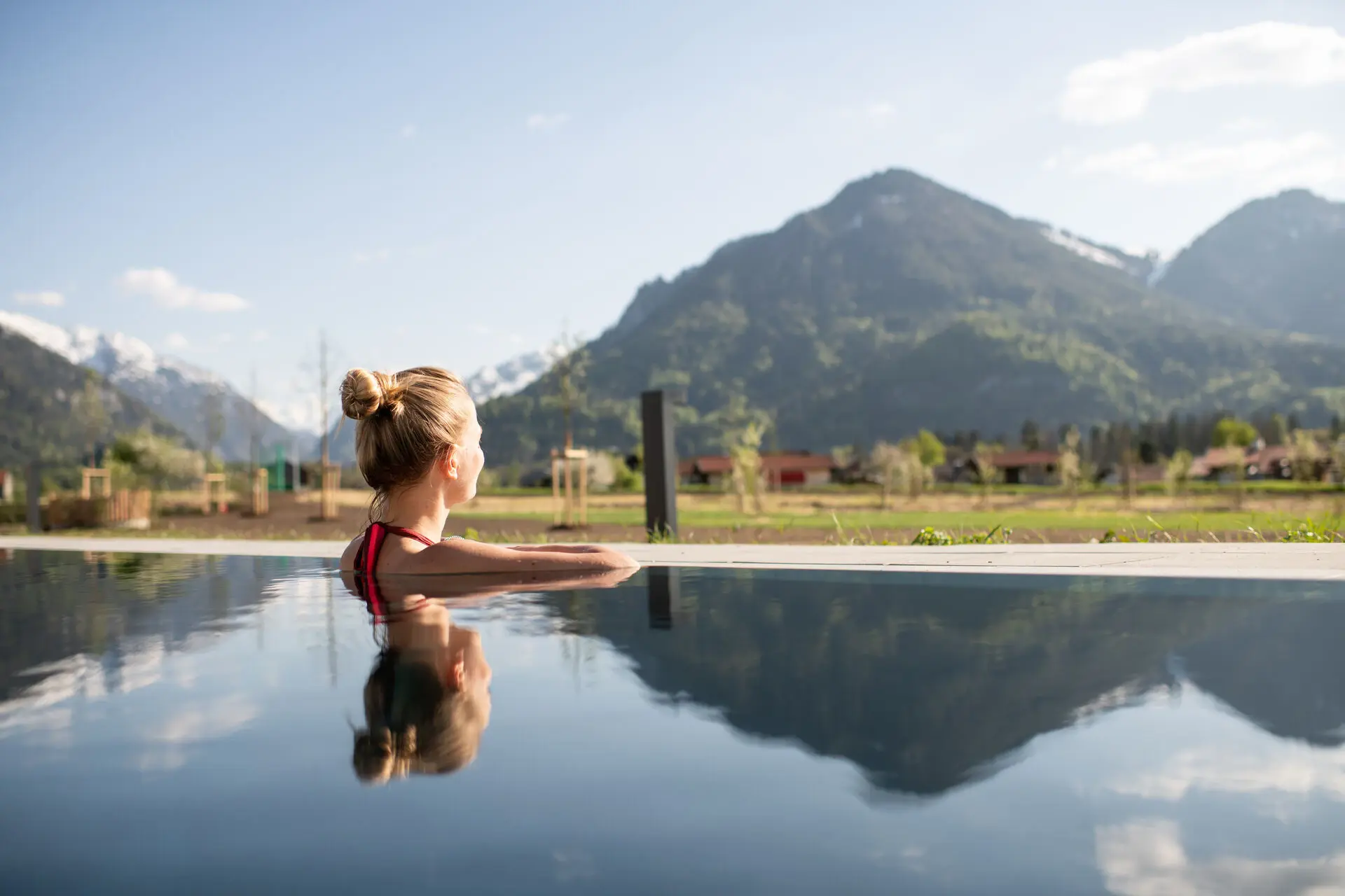 Frau im Außenpool mit Blick auf die Berge