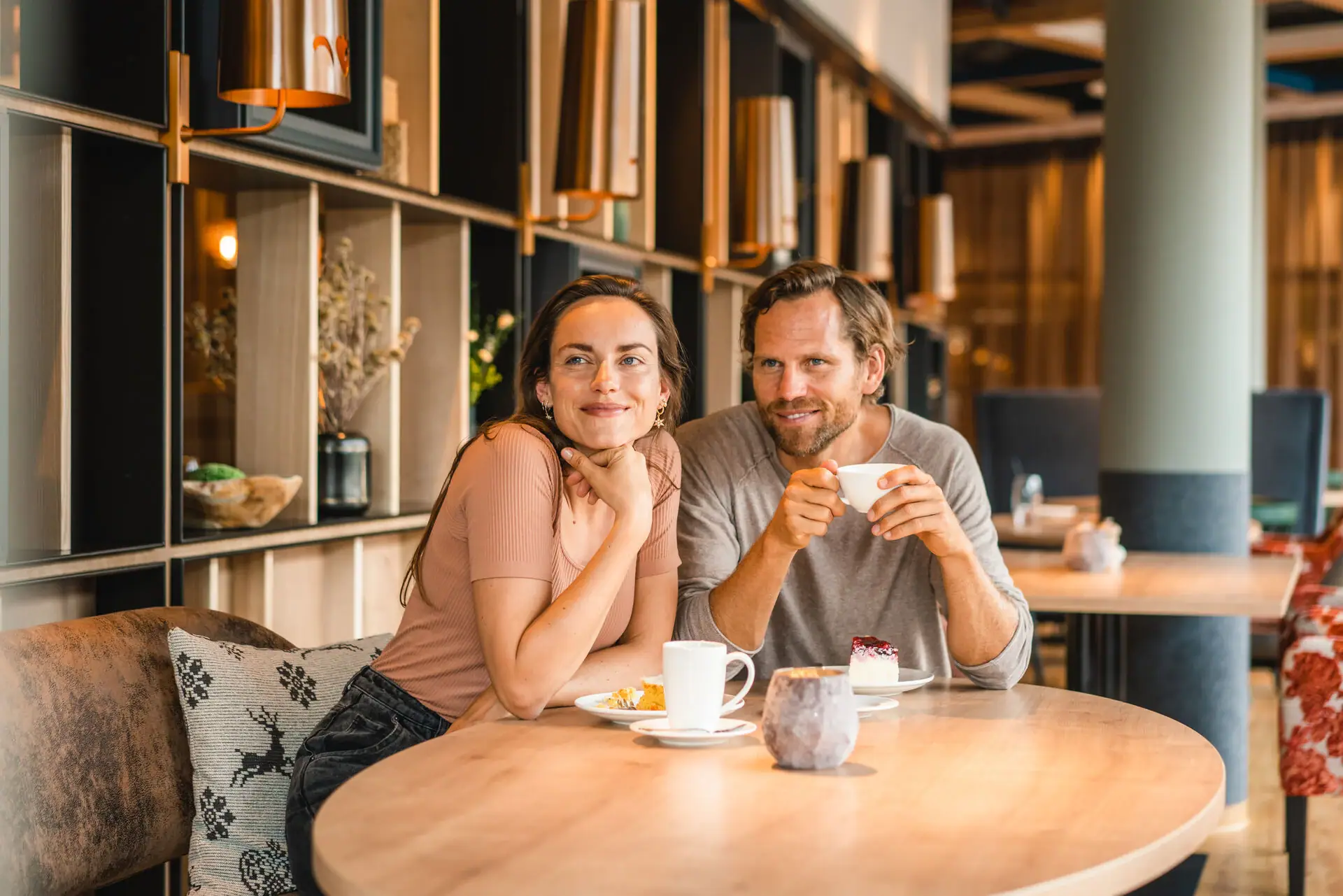 Kaffeetrinken Ein Mann und eine Frau sitzen an einem Tisch mit Essen und Getränken.
