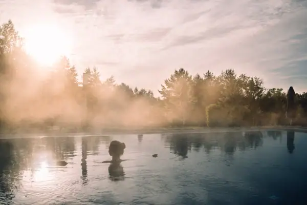 aja SPA in Bad Saarow Eine Person im Wasser, umgeben von Bäumen.