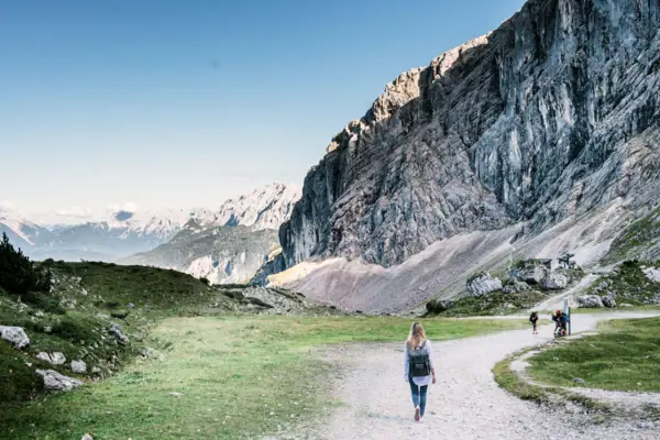 Genuss-Erlebnisweg Eine Frau geht auf einem Pfad mit einem großen Berg im Hintergrund.
