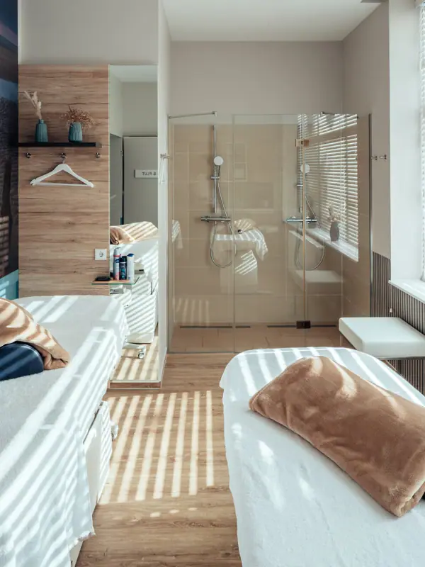 Anwendungsraum Ein Zimmer mit zwei Betten und einer Dusche.