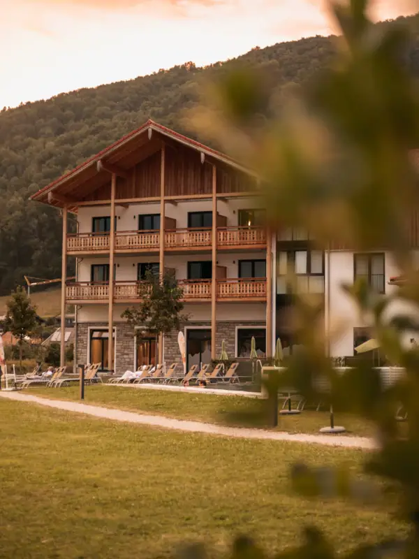 aja Ruhpolding Ein Gebäude mit Rasen und Stühlen davor.