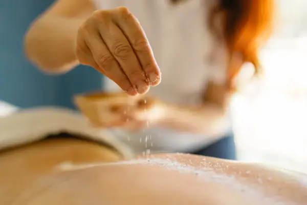 Ruhe des Waldes - Kombination Eine Person streut Salz auf den Rücken einer anderen Person.