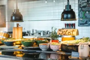 Buffet-Tisch mit Schüsseln voller Speisen in einem Innenraum.