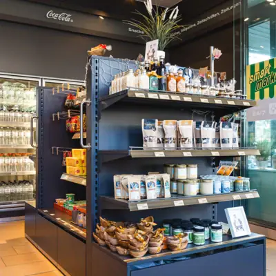 Einzelhandelsgeschäft mit Regalen voller Lebensmittel und Getränke.