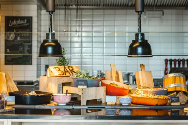 Abendessen im aja Warnemünde Ein Tresen mit Schüsseln voller Gerichte.