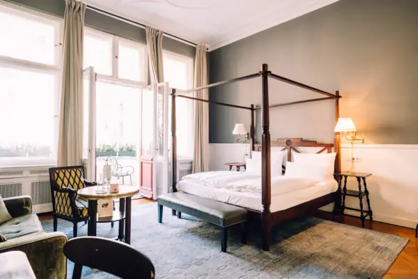 Zimmer HENRI Berlin Ein Zimmer mit einem Himmelbett und einem Tisch.