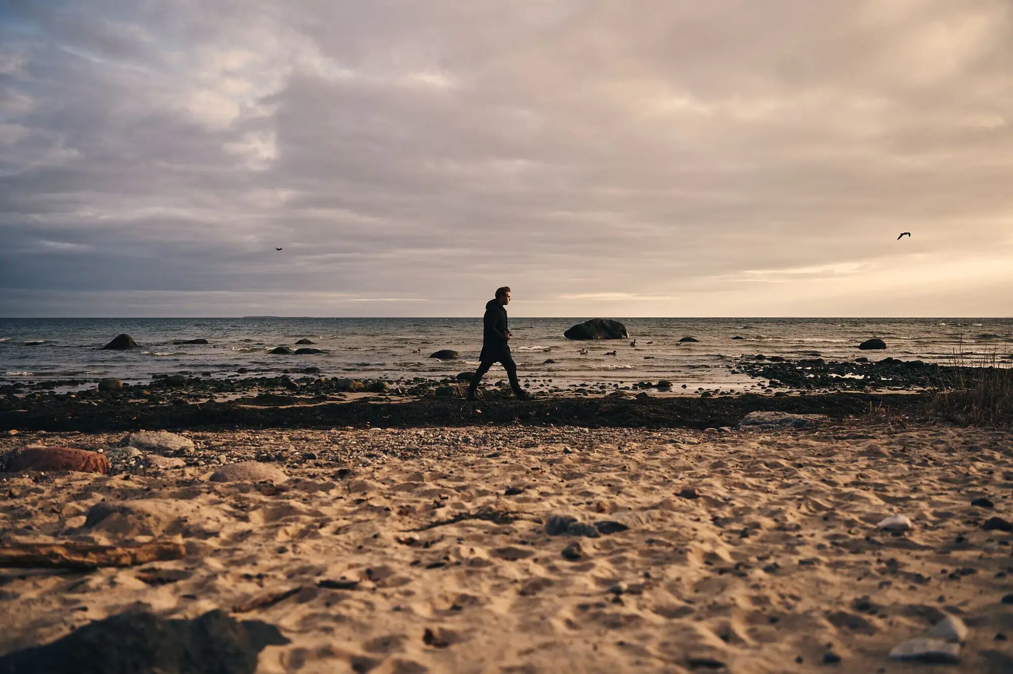 Strand von Göhren Eine Person geht am Strand entlang.