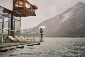 aja Fürstenhaus am Achensee Eine Person steht auf einem Steg mit einem Regenschirm.