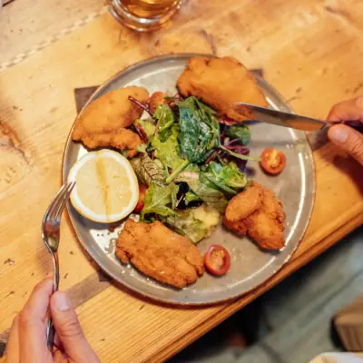 Schnitzel Eine Person isst ein Tellergericht mit Fast Food.
