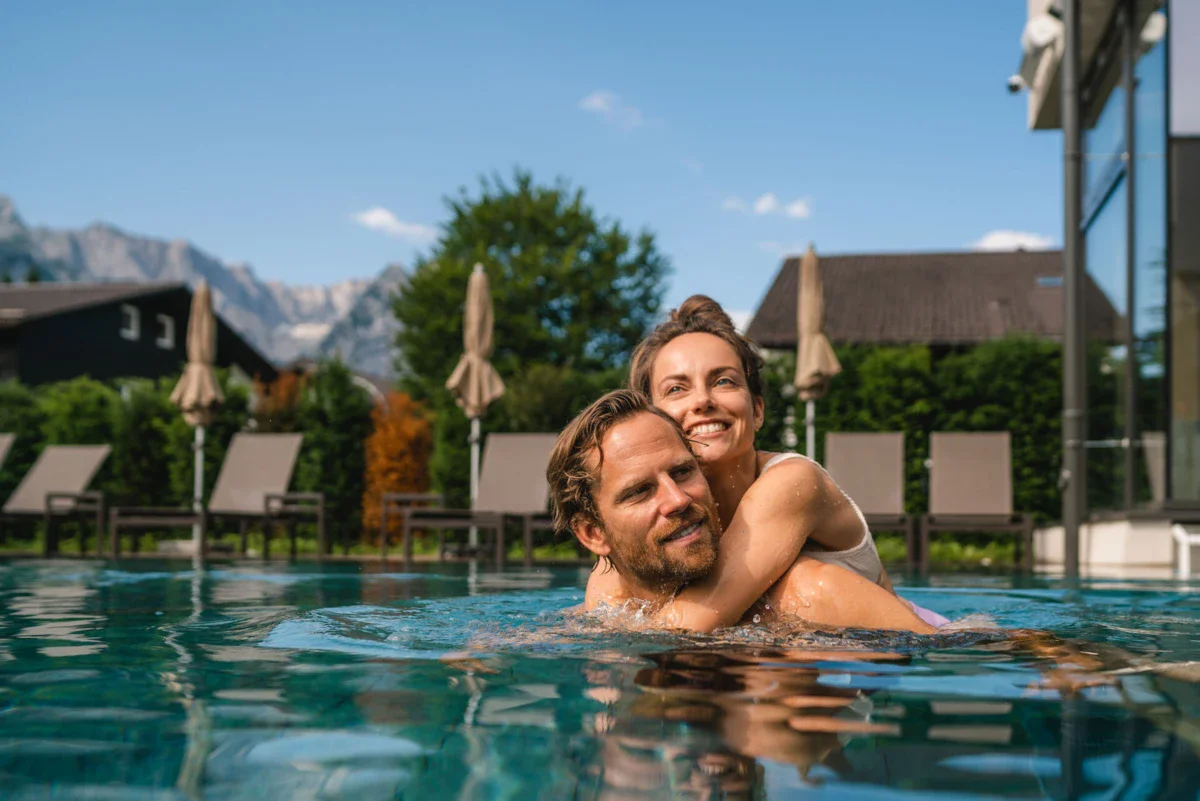 Außenpool Ein Mann und eine Frau im Pool, beide lächelnd.