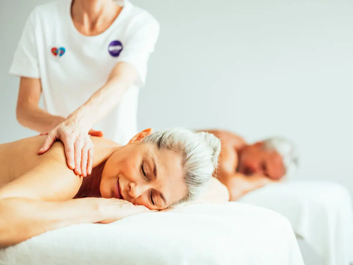 Paarmassage Eine Frau liegt auf einem Bett mit einem Mann.