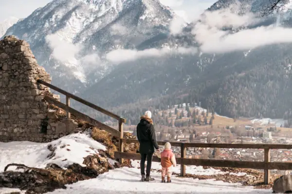 Winterlandschaft Eine Frau und ein Kind stehen auf einem verschneiten Berg.