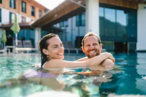 Außenpool Ein Mann und eine Frau in einem Pool, beide lächeln.