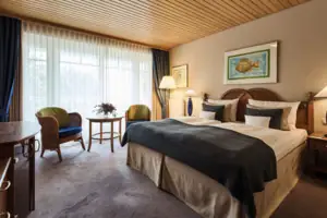 Doppelzimmer Schlafzimmer mit Bett und Stühlen, ausgestattet mit Kissen und Bettwäsche.