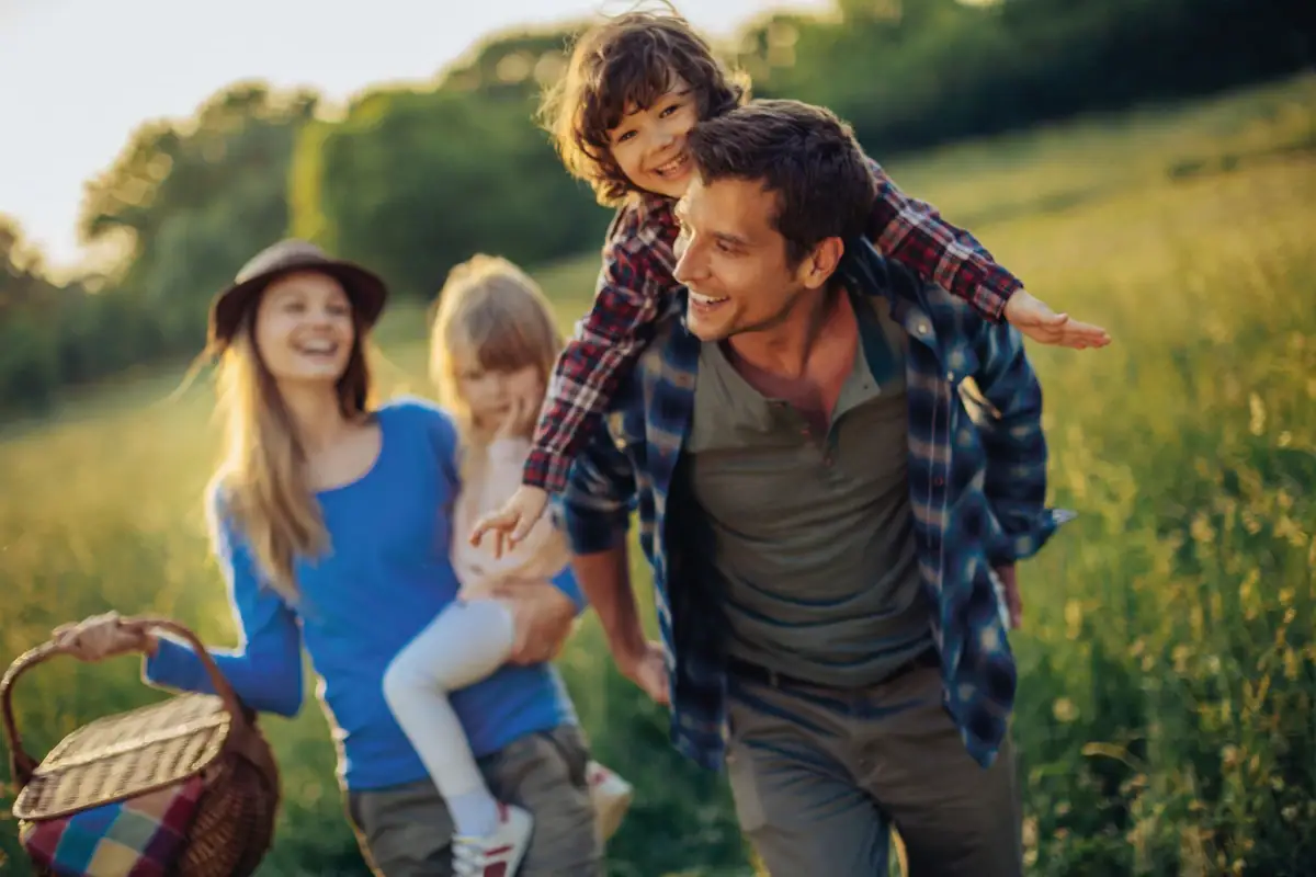 Familienausflug mit Kindern Usedom Ein Mann trägt ein Kind auf seinen Schultern im Freien bei einem Familienausflug.