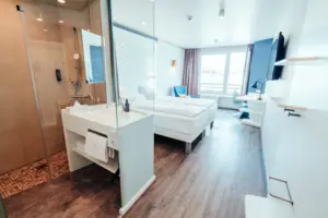 Doppelzimmer Landseite Ein Raum mit zwei Betten und einer Dusche.