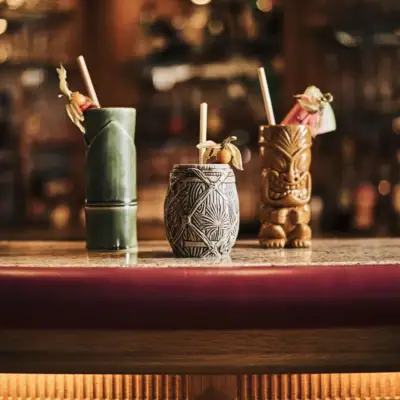 Südstrand Bar Eine Gruppe von Tiki-Bechern auf einer Theke.