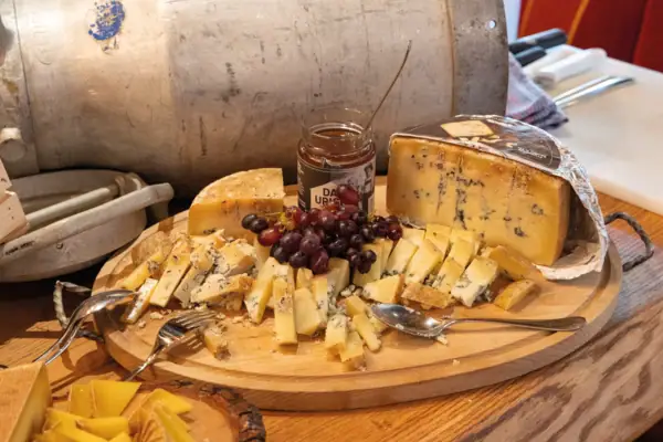 Käse Ein Teller mit Käse und Trauben.