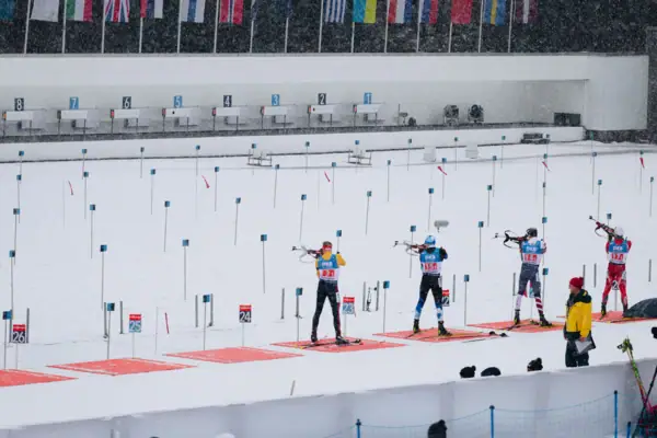 Biathlon Eine Gruppe von Menschen in Biathlon-Ausrüstung im Schnee.