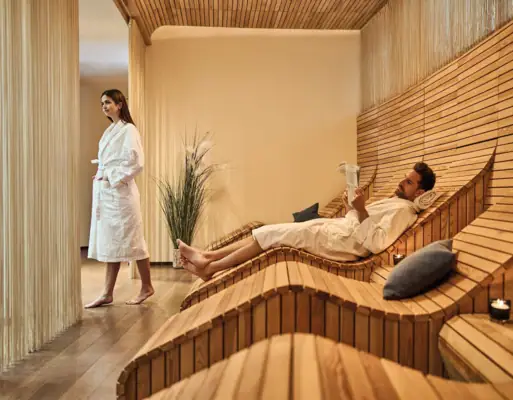 Wellnessbereich Werfenweng Ein Mann und eine Frau in einem Raum mit Holzbänken.