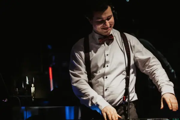 Silvester im aja Warnemünde Ein Mann trägt eine Fliege und Kopfhörer.