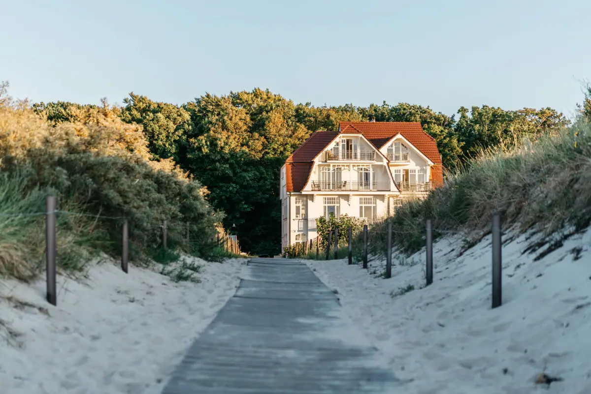 STrandaufgang Warnemünde Ein Weg, der zu einem Haus führt.