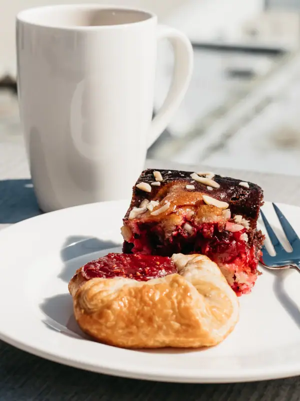 Kaffee und Kuchen Ein Teller mit Gebäck und eine Tasse Kaffee auf einem Tisch.