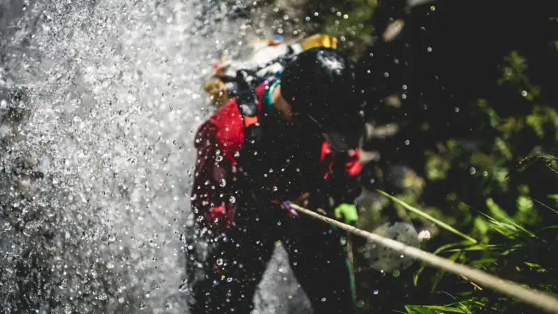 Canyoning Eine Person mit Helm und Kletterausrüstung.