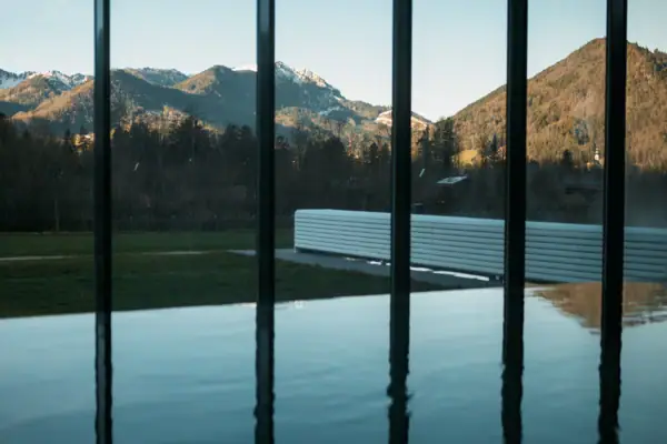 Innenpool Große Glaswand mit Blick auf Berge und Gras.