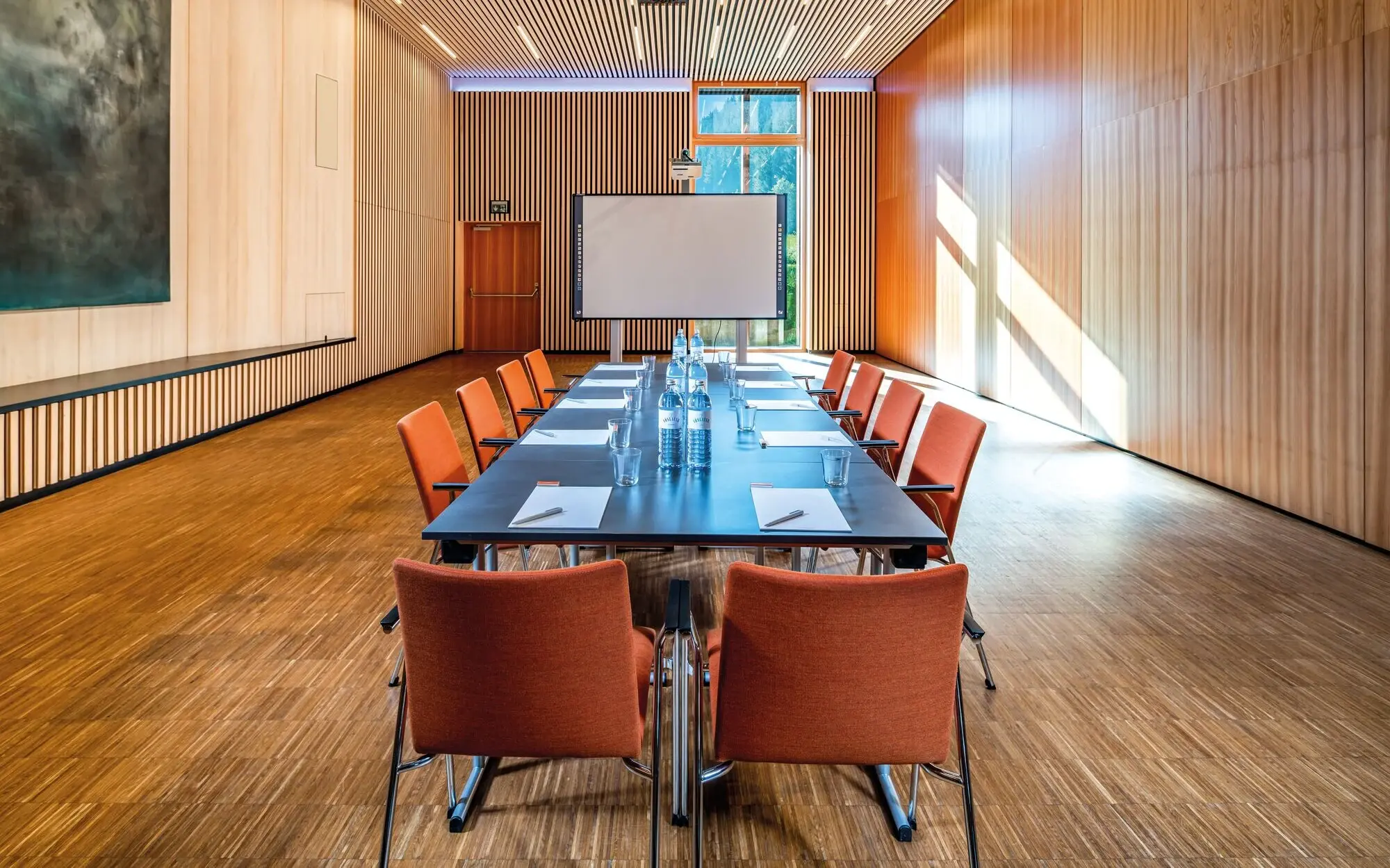 Konferenzraum mit Tisch und Stühlen.