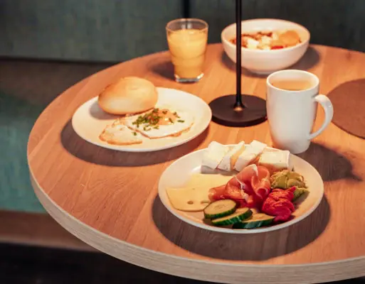 Frühstück Ein Tisch mit Tellern voller Essen und einer Lampe.