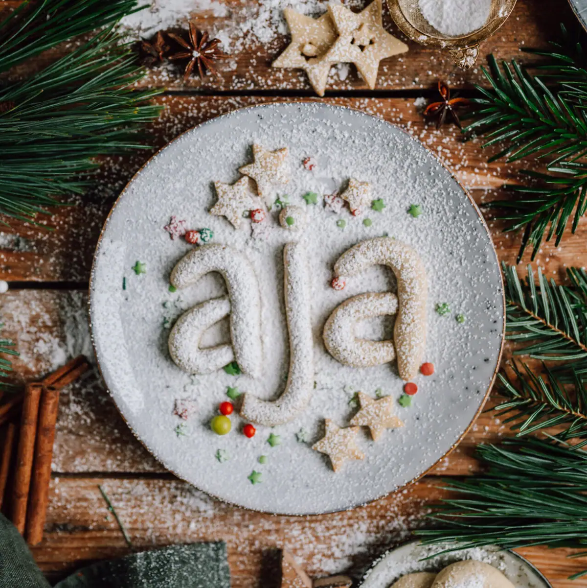 aja Plätzchen Ein Teller mit Keksen und einem Namen darauf.