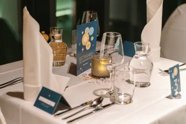 Silvesterparty im aja Bad Saarow Ein Tisch mit einer Kerze und Gläsern.