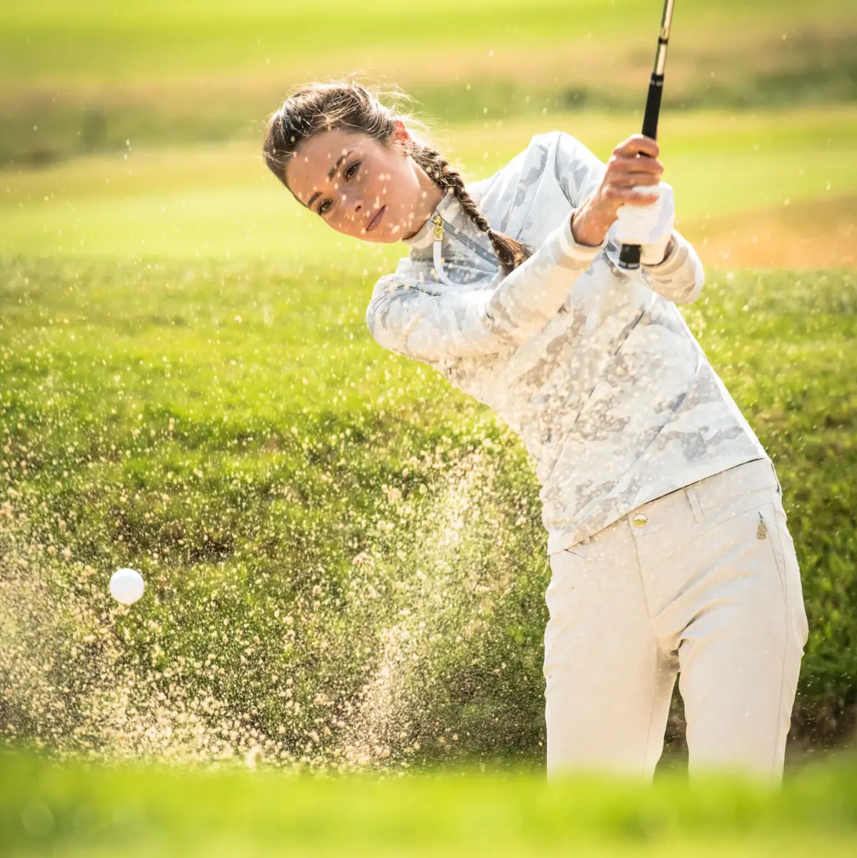 Platzreife Eine Frau schwingt einen Golfschläger auf einem Golfplatz in Ruhpolding.