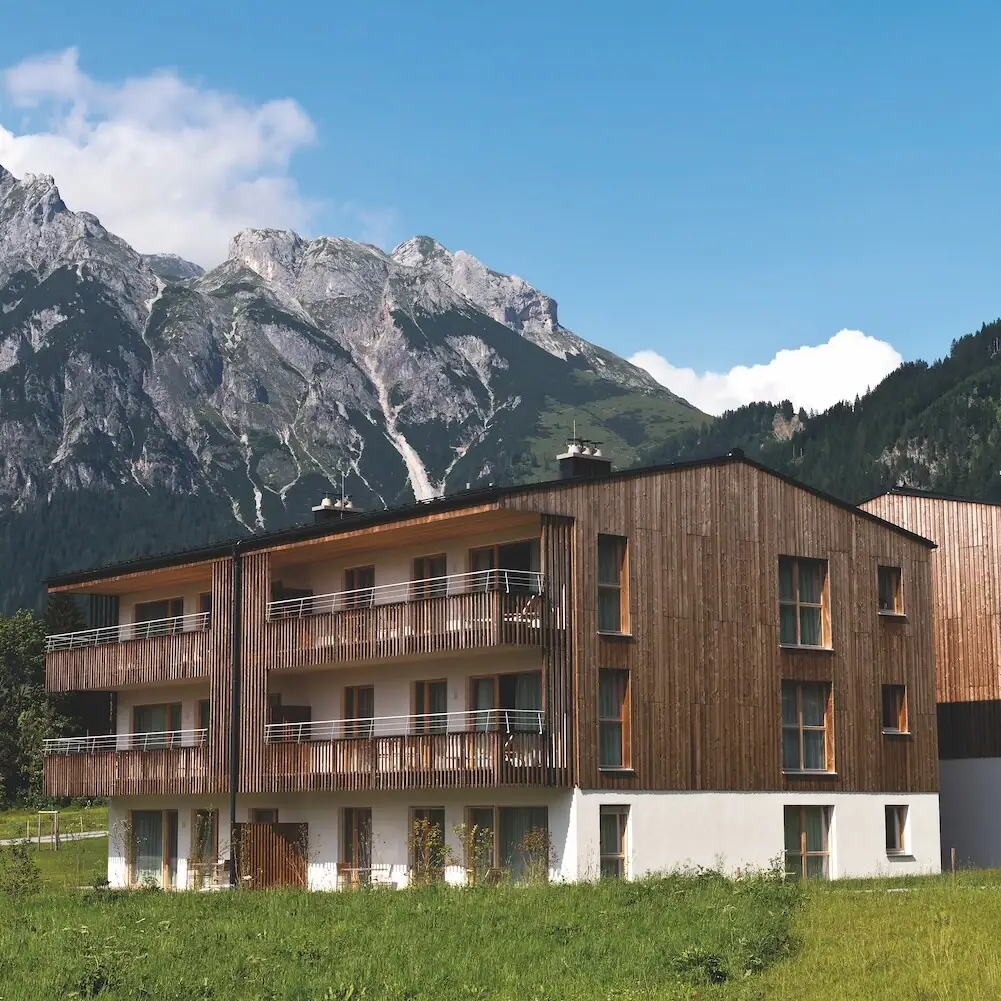 Ferienwohnungen Werfenweng Ein Gebäude mit einem Berg im Hintergrund.