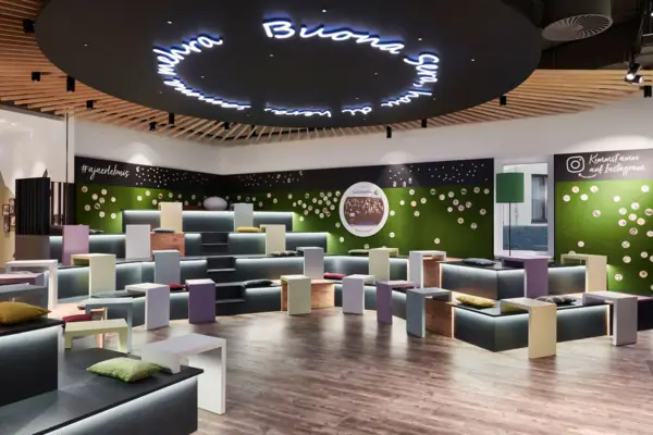 Barbereich im aja Ruhpolding Ein Raum mit vielen bunten Bänken und Tischen.