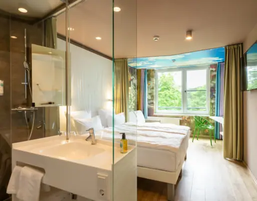 aja Bad Saarow Zimmer Ein Raum mit einer Glasdusche und zwei Betten.