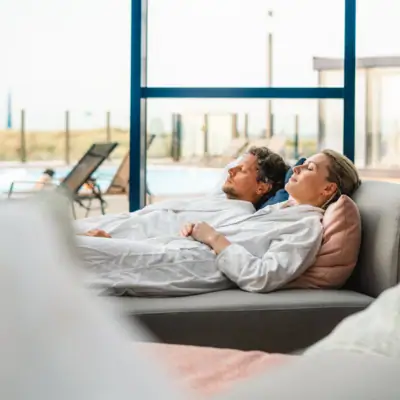 DaySPA im aja Warnemünde Ein Mann und eine Frau liegen auf einem Sofa.