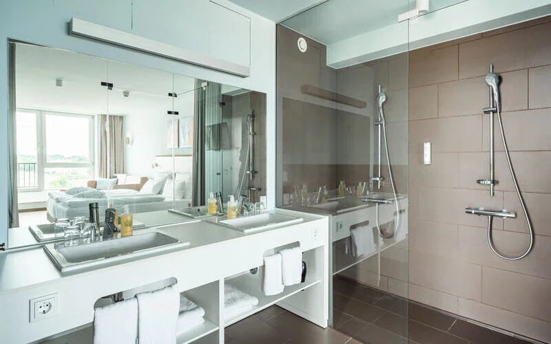 Badezimmer Suite Ein weißes Badezimmer mit zwei Waschbecken und einer Dusche
