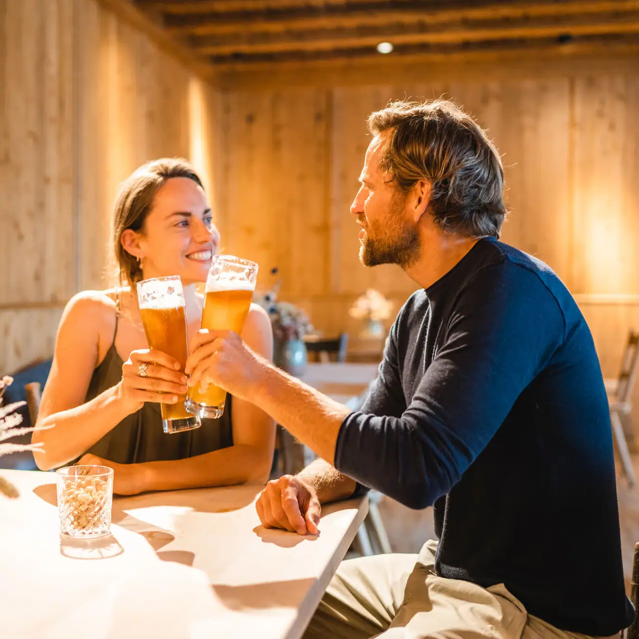 Bayerische Stube Ein Mann und eine Frau sitzen an einem Tisch mit Biergläsern.