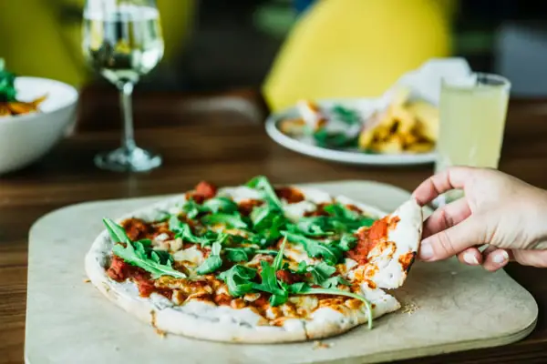 Pizza Eine Hand hält eine Pizza.